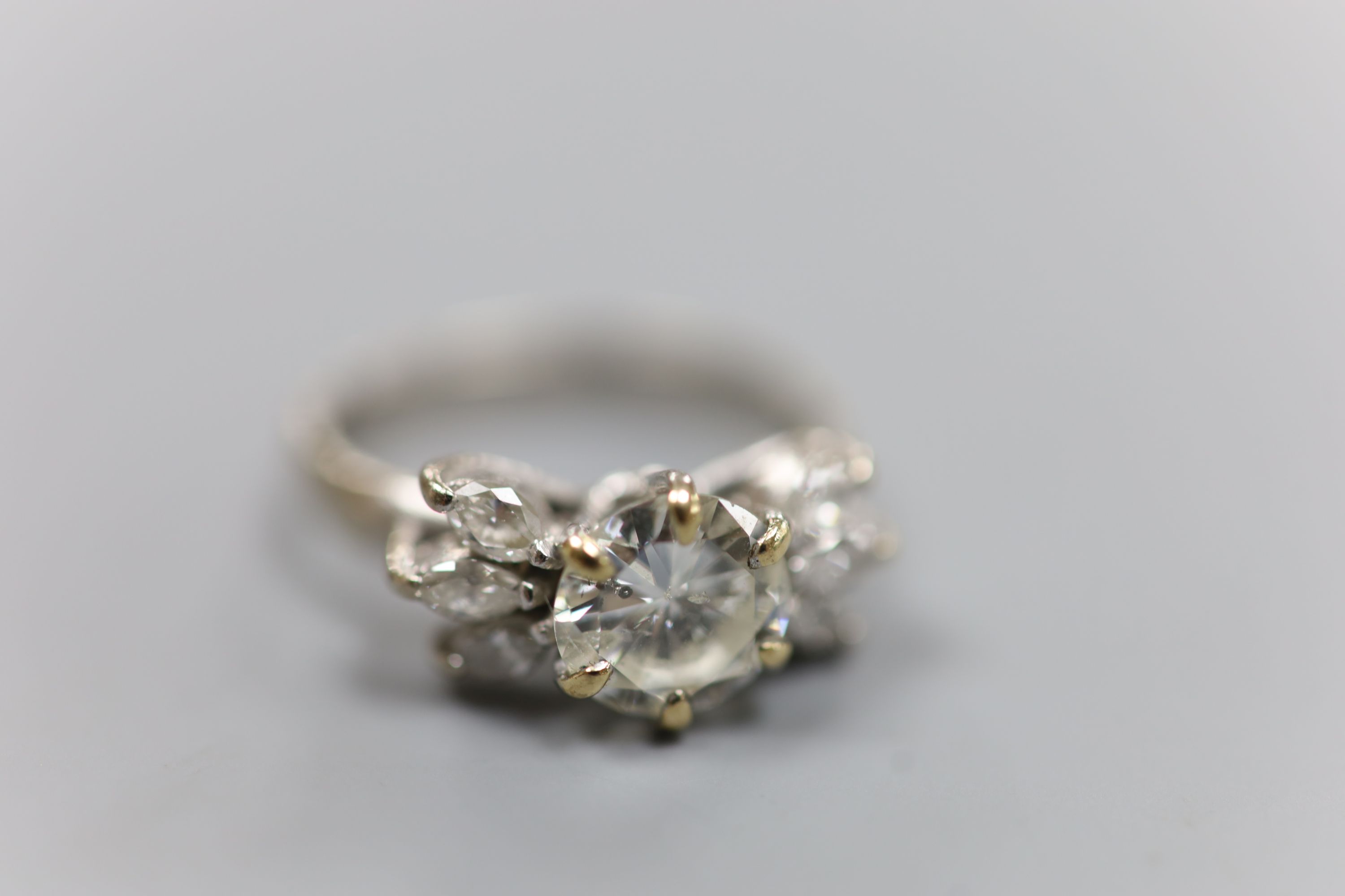 A white metal (stamped 18ct Plat) and single stone diamond ring, with six stone marquise cut diamond set shoulders, size K